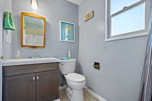 Bathroom with vanity, tile patterned flooring, and toilet