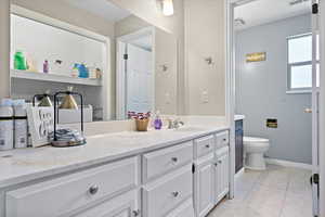 Bathroom featuring tile patterned flooring, vanity, and toilet