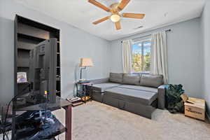 Living room with ceiling fan and carpet flooring