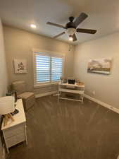 Carpeted home office with ceiling fan