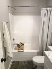 Full bathroom featuring shower / bath combination with curtain, vanity, and toilet