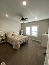 Carpeted bedroom featuring ceiling fan and washer / dryer