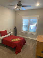 Carpeted bedroom featuring ceiling fan