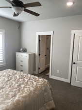 Bedroom with ceiling fan and dark carpet