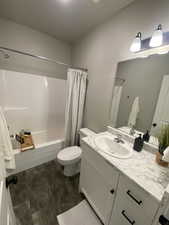 Full bathroom with vanity, toilet, and shower / bath combo with shower curtain