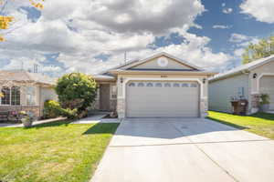 View of front of home with a front yard and a garage