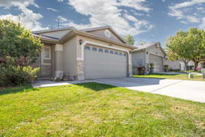 View of front of property featuring a garage and a front lawn