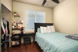 Bedroom with ceiling fan, a closet, and dark hardwood / wood-style floors