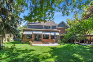 Back of house with french doors, a lawn, and a patio area