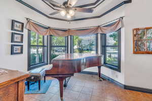 Miscellaneous room with ceiling fan, light tile patterned floors, ornamental molding, and a wealth of natural light