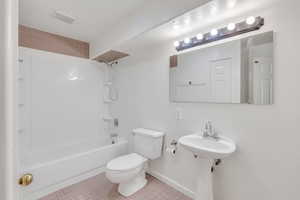 Full bathroom featuring sink, tile patterned flooring, shower / washtub combination, and toilet