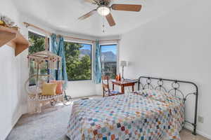 Bedroom featuring ceiling fan, carpet, and multiple windows