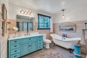 Full bathroom featuring vanity, a textured ceiling, wood-type flooring, separate shower and tub, and toilet