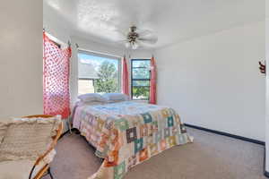 Bedroom featuring ceiling fan, carpet floors, and a textured ceiling