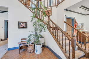 Staircase featuring a high ceiling and tile patterned flooring