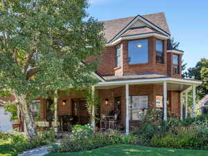 View of front facade featuring a front lawn and covered porch