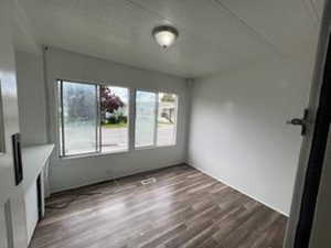 Unfurnished room with wood-type flooring and a healthy amount of sunlight