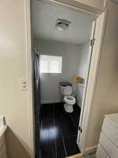 Bathroom with vanity, hardwood / wood-style flooring, and toilet