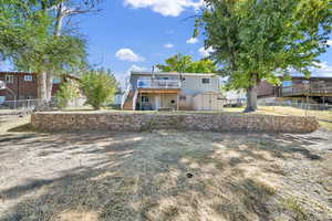 Rear view of house featuring a deck and a storage unit