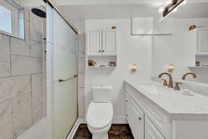 Bathroom featuring tile patterned flooring, walk in shower, vanity, and toilet