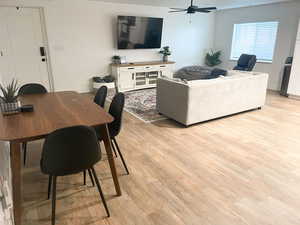 Living room with ceiling fan and light wood-type flooring