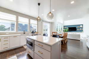 Kitchen with appliances with stainless steel finishes, decorative light fixtures, sink, and a wealth of natural light