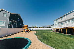 View of yard with a playground and a deck