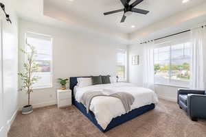 Bedroom featuring multiple windows, carpet floors, and ceiling fan