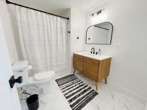 Bathroom with a shower with curtain, a textured ceiling, vanity, and toilet