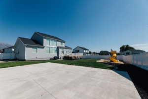 Exterior space featuring a playground, a wooden deck, and a lawn