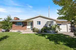 Ranch-style house featuring a front lawn and a garage