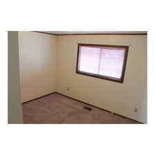 Spare room with carpet flooring, visible vents, and baseboards