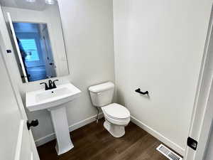 Bathroom with toilet and hardwood / wood-style flooring