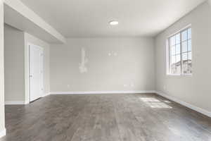 Unfurnished room with dark wood-type flooring