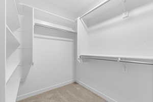 Walk in closet featuring light colored carpet