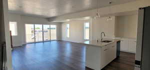 Kitchen featuring a kitchen island with sink, white cabinetry, sink, and dark hardwood / wood-style flooring