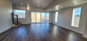 Unfurnished room with a textured ceiling and dark hardwood / wood-style flooring