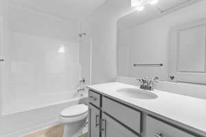 Full bathroom featuring tile patterned flooring, washtub / shower combination, vanity, and toilet