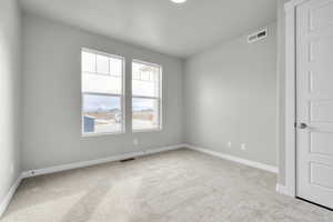 Unfurnished room featuring light carpet