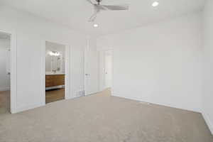 Unfurnished bedroom featuring connected bathroom, light carpet, and ceiling fan