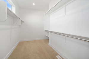 Walk in closet with light carpet