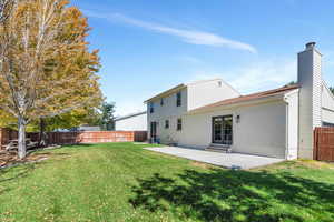 Rear view of house with a lawn and a patio area