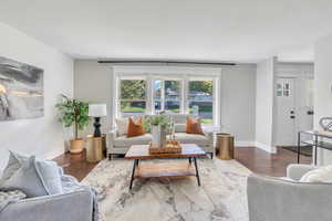 Living room featuring a textured ceiling, wood walls, and dark hardwood / wood-style flooring