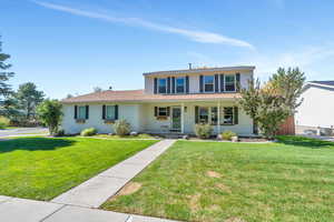 View of front property featuring a front lawn and covered porch