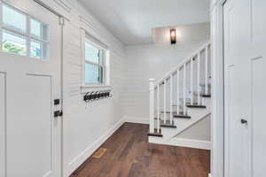 Entrance foyer featuring wooden walls and dark hardwood / wood-style flooring