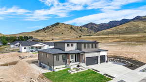 View of front of property featuring central AC unit, a mountain view, and a garage