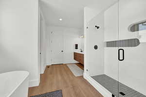 Bathroom featuring separate shower and tub, vanity, and hardwood / wood-style floors