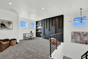 Interior space with a textured ceiling, light carpet, and a notable chandelier