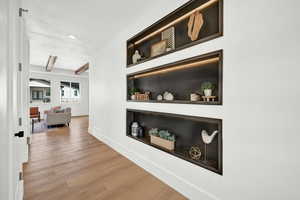 Hall with wood-type flooring and beamed ceiling