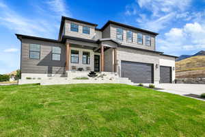 View of front of house with a garage and a front lawn